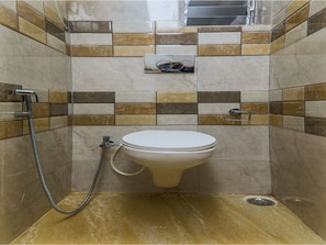 A bathroom with a toilet, shower, and tiled walls. - OYO 16719 Airport Guest House (Guwahati)