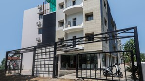 A multi-story building with balconies, a gated entrance, and a parked scooter. - OYO 16719 Airport Guest House (Guwahati)