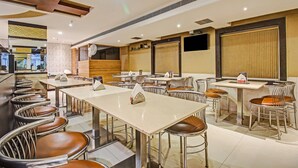 Un restaurant spacieux avec de nombreuses tables et chaises, un bar et un comptoir.