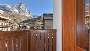 A wooden balcony with a view of mountains and a sign for "MARTORELLI SPA & HOTEL". - Residence Castelli (Valtournenche)