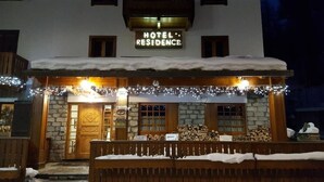 A hotel with a stone facade, wooden entrance, and a sign reading "HOTEL RESIDENCE." - Residence Castelli (Valtournenche)