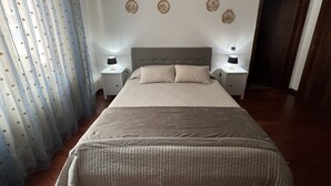 A bedroom with a large bed, two bedside tables with lamps, a ceiling light, and a door. - 10 Minutes B&B (Verona)