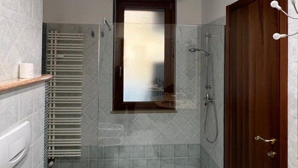 A modern bathroom with a walk-in shower, a toilet, and a sink. - 10 Minutes B&B (Verona)