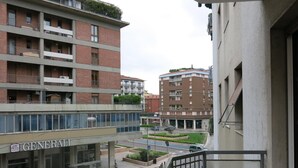 A multi-story building with a 'GENERAL' sign, a pedestrian bridge, and a road with cars. - 10 Minutes B&B (Verona)