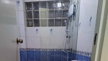 A bathroom with a toilet, bidet, and shower.