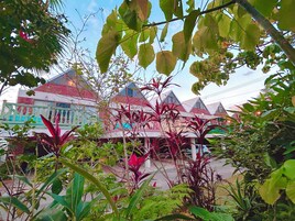 A building with multiple roofs and a balcony with hanging lights.