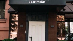 Entrada de un edificio con un letrero que dice 'MALON apartments'.