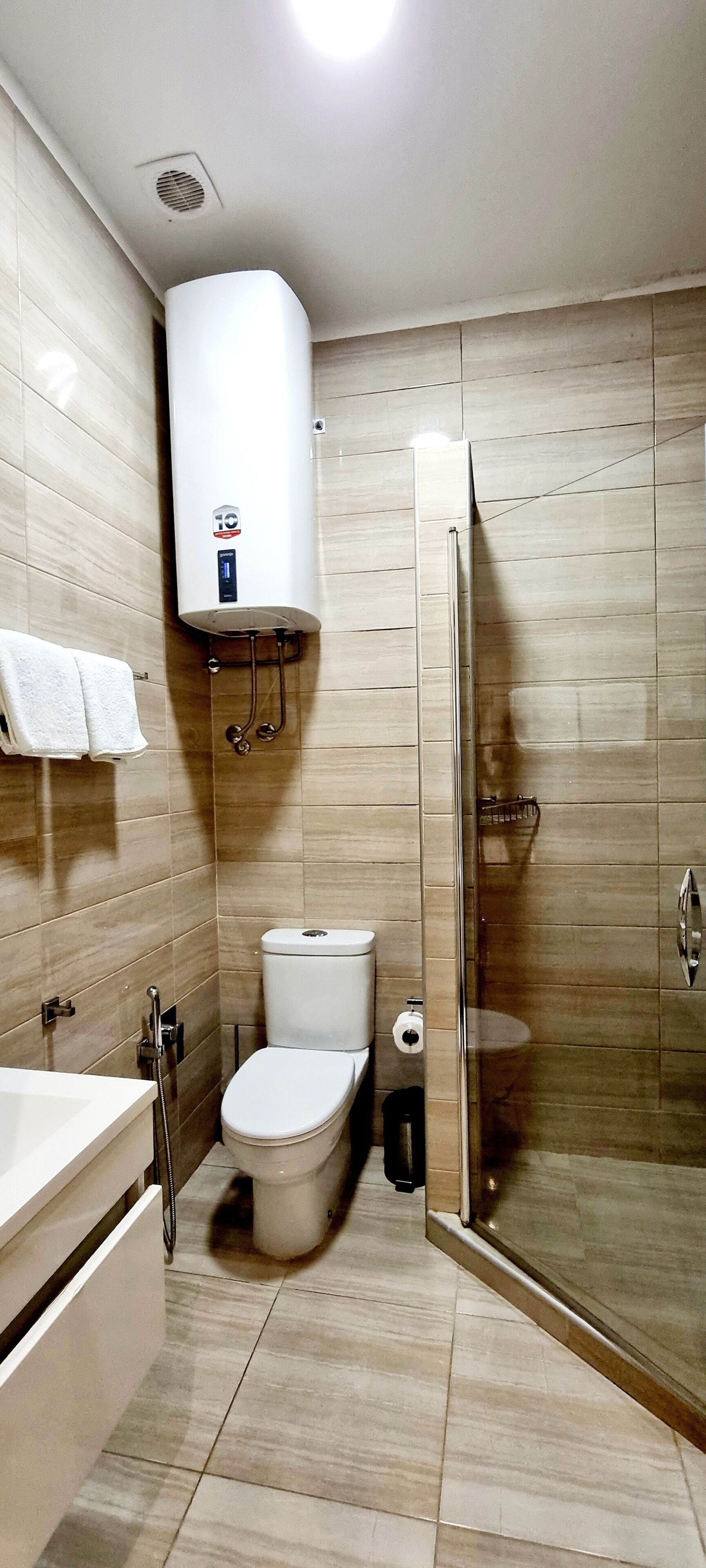 A modern bathroom with a toilet, sink, and shower.