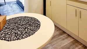 Una cocina moderna con una mesa redonda, una cafetera y vistas a un paisaje urbano.
