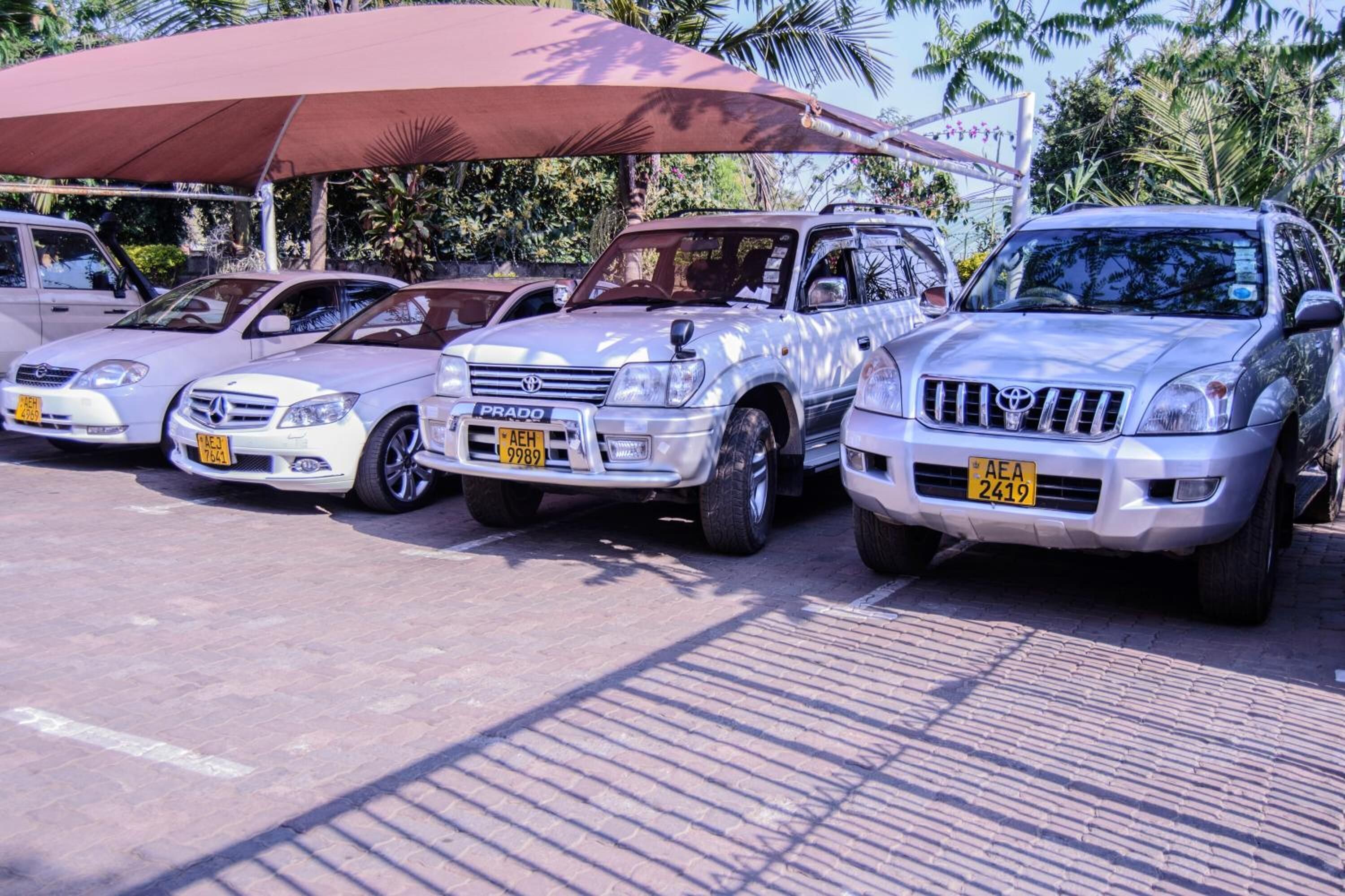 Ein Parkplatz mit mehreren Autos, darunter ein weißer Mercedes-Benz und ein silberner Toyota SUV.
