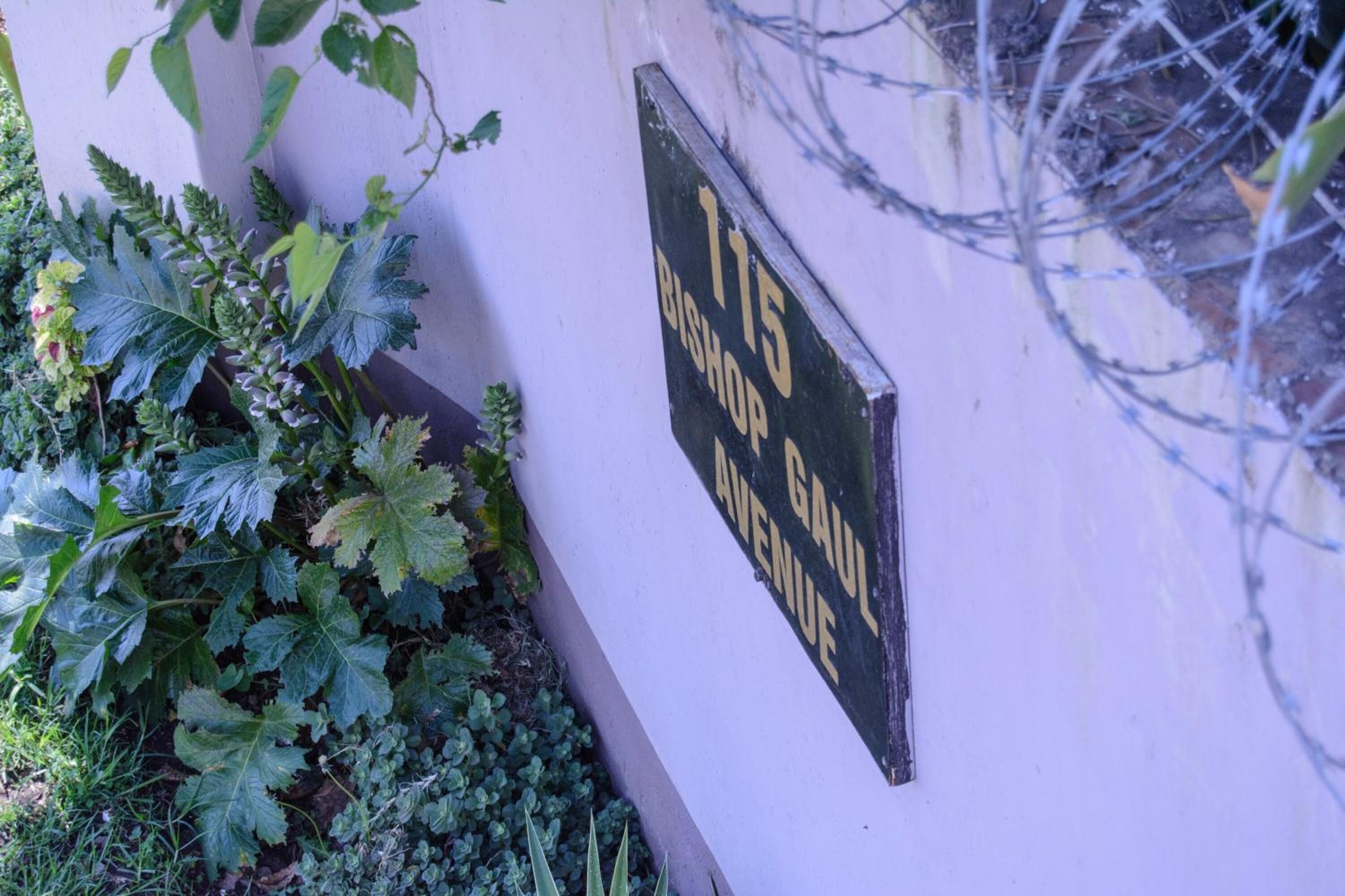 Une enseigne indiquant l’adresse « 115, avenue Bishop Gaul » est fixée à un mur.