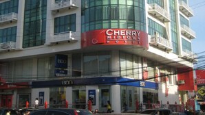 A multi-story hotel with a prominent red and white facade, large glass windows, and balconies. - Cherry Midtown Hotel (Olongapo)