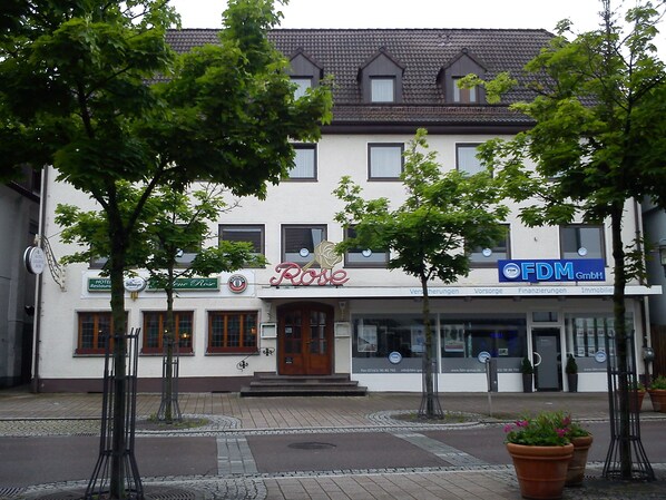 A building with a rose sign, a restaurant, and a FDM company. - Hotel Rose (Ebersbach an der Fils)