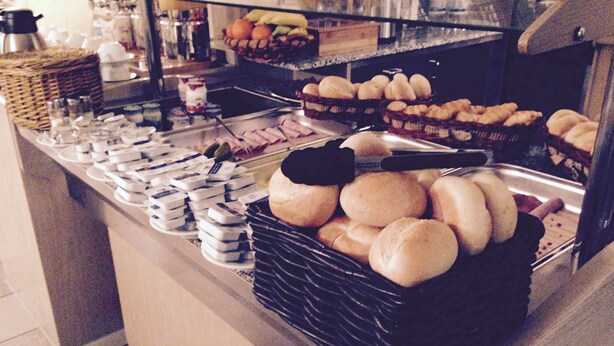 A bakery display with various baked goods and condiments. - Hotel Rose (Ebersbach an der Fils)