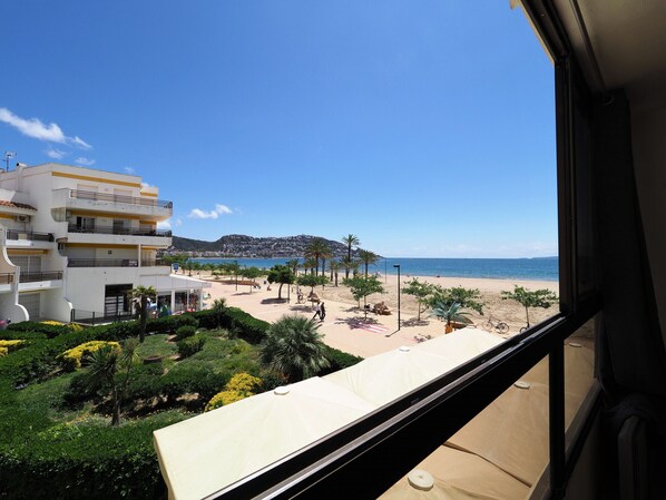 A view from a balcony overlooking a beach with a mountain in the background. - Nice apartment in front of the sea in Roses Inmosantos Oasis A3 (Rosas / Roses)