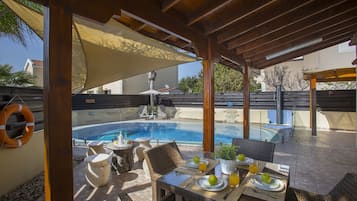 Una piscina al aire libre, sillones reclinables de piscina