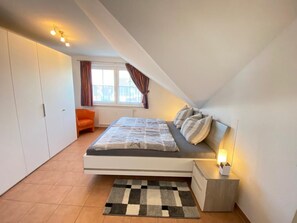 Un dormitorio con cama, mesita de noche y armario.