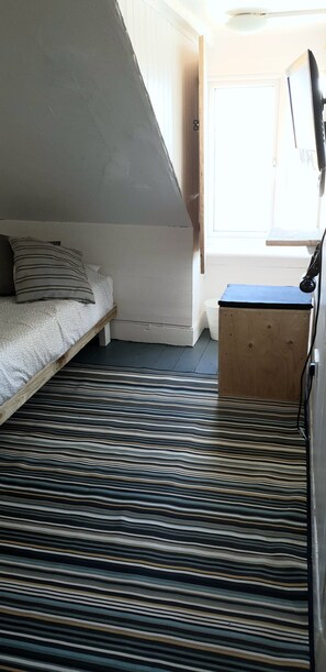 A compact bedroom with a bunk bed, a small wooden desk, and a window providing natural light. - Bunkhouse Bournemouth - Hostel (Bournemouth)