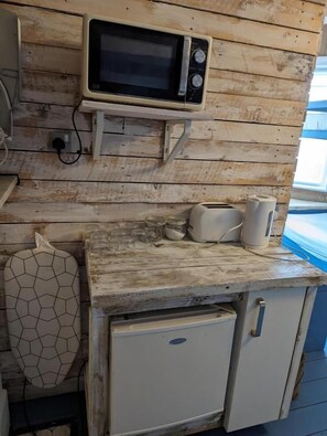A compact kitchenette with a microwave, toaster, and small refrigerator. - Bunkhouse Bournemouth - Hostel (Bournemouth)