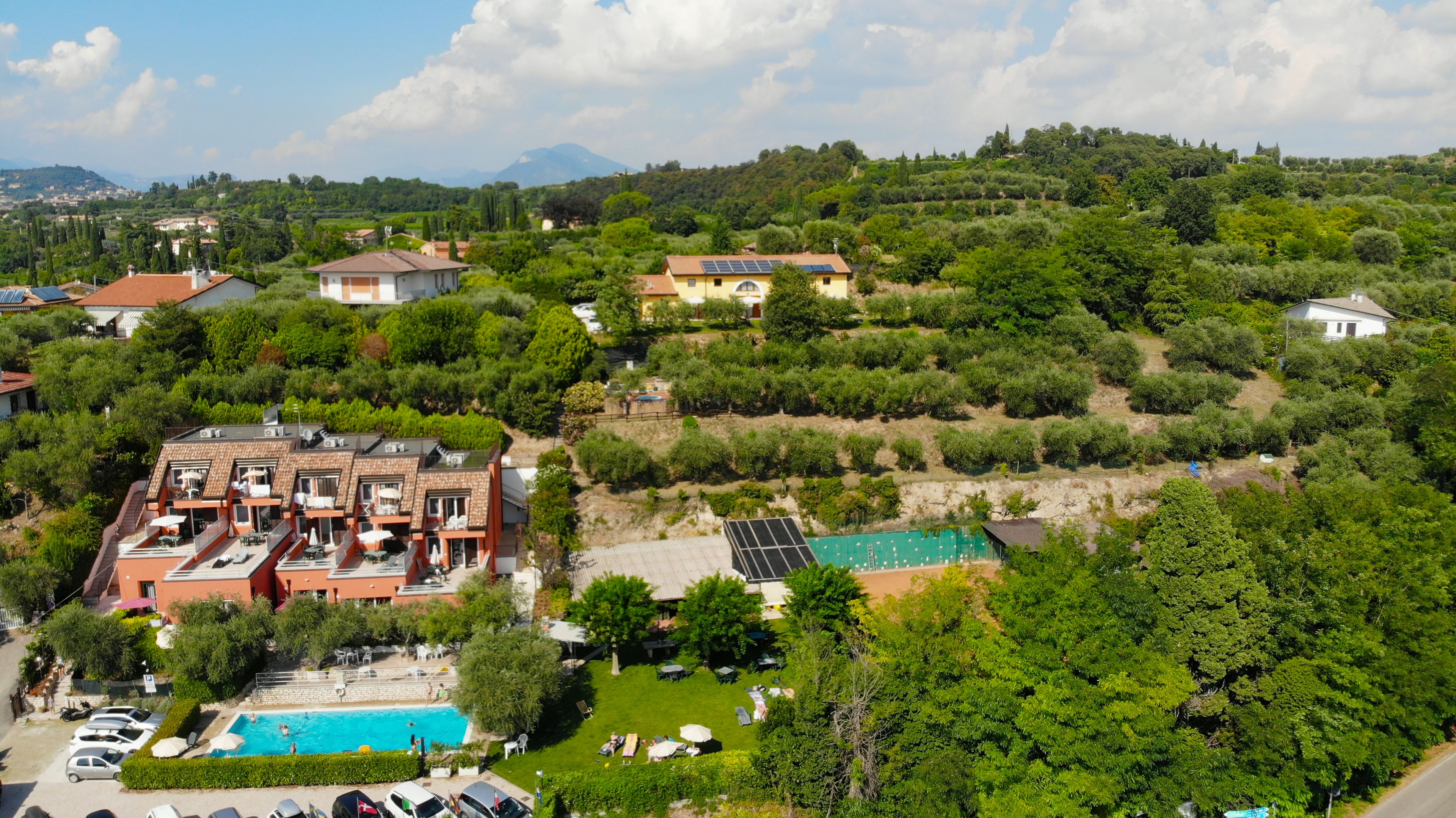 Un quartier résidentiel doté d’une piscine, de panneaux solaires et d’une colline boisée.
