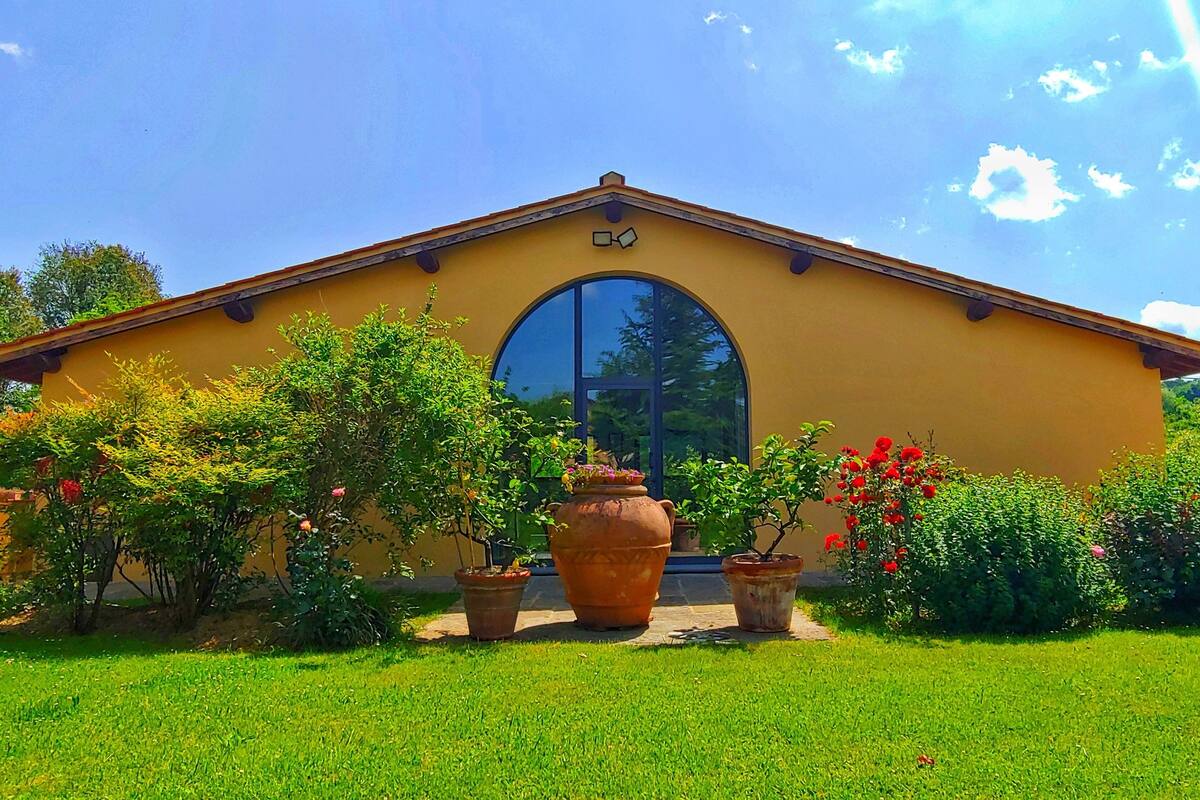 A yellow building with a large arched window and a small balcony.