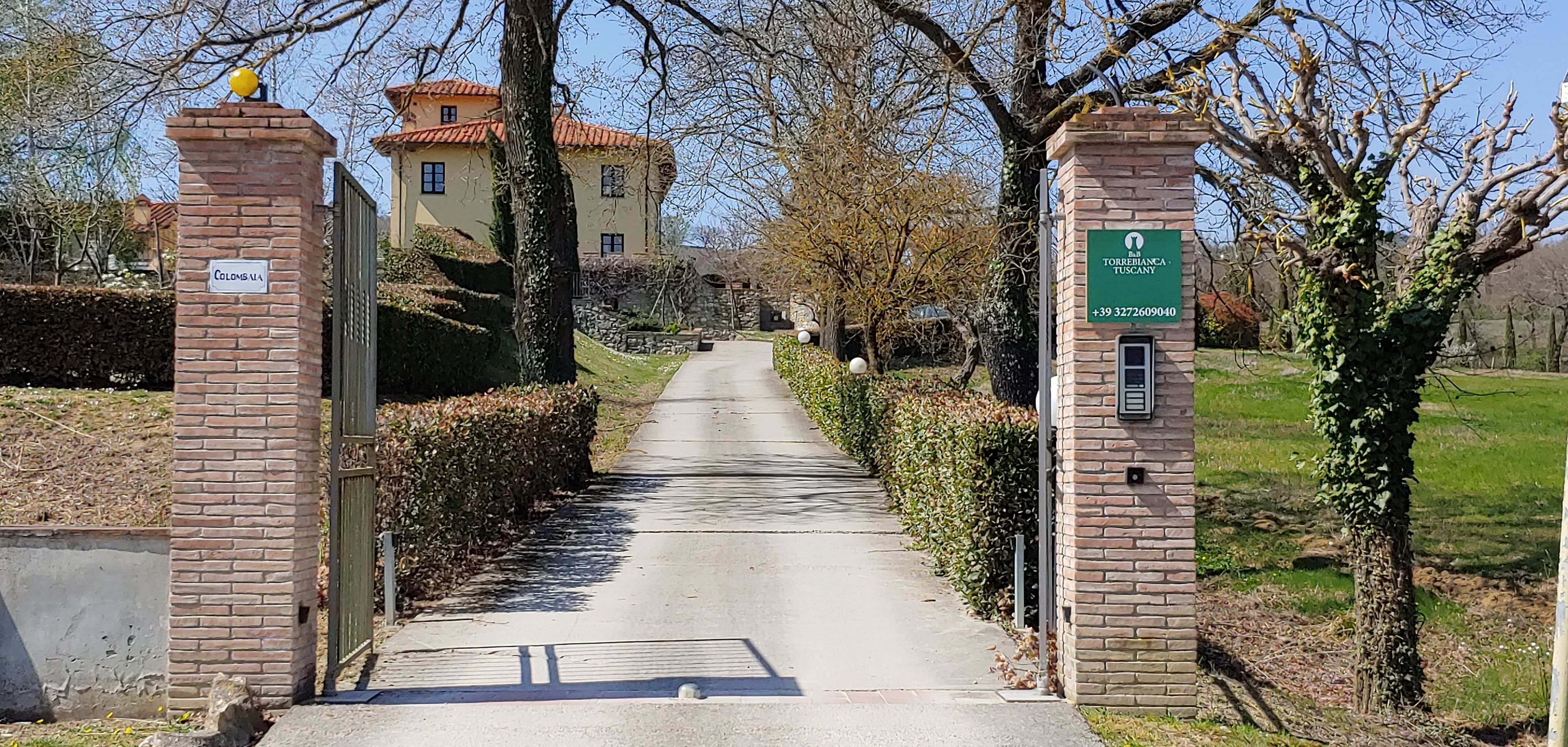 A gated entrance to a property with a clear pathway leading to a building.