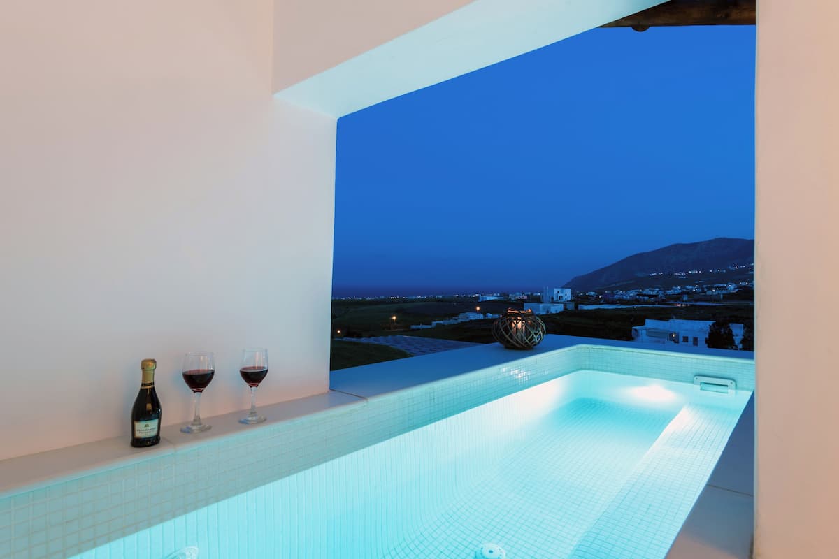 Una piscina infinita moderna con vistas a un paisaje lejano y un horizonte urbano.