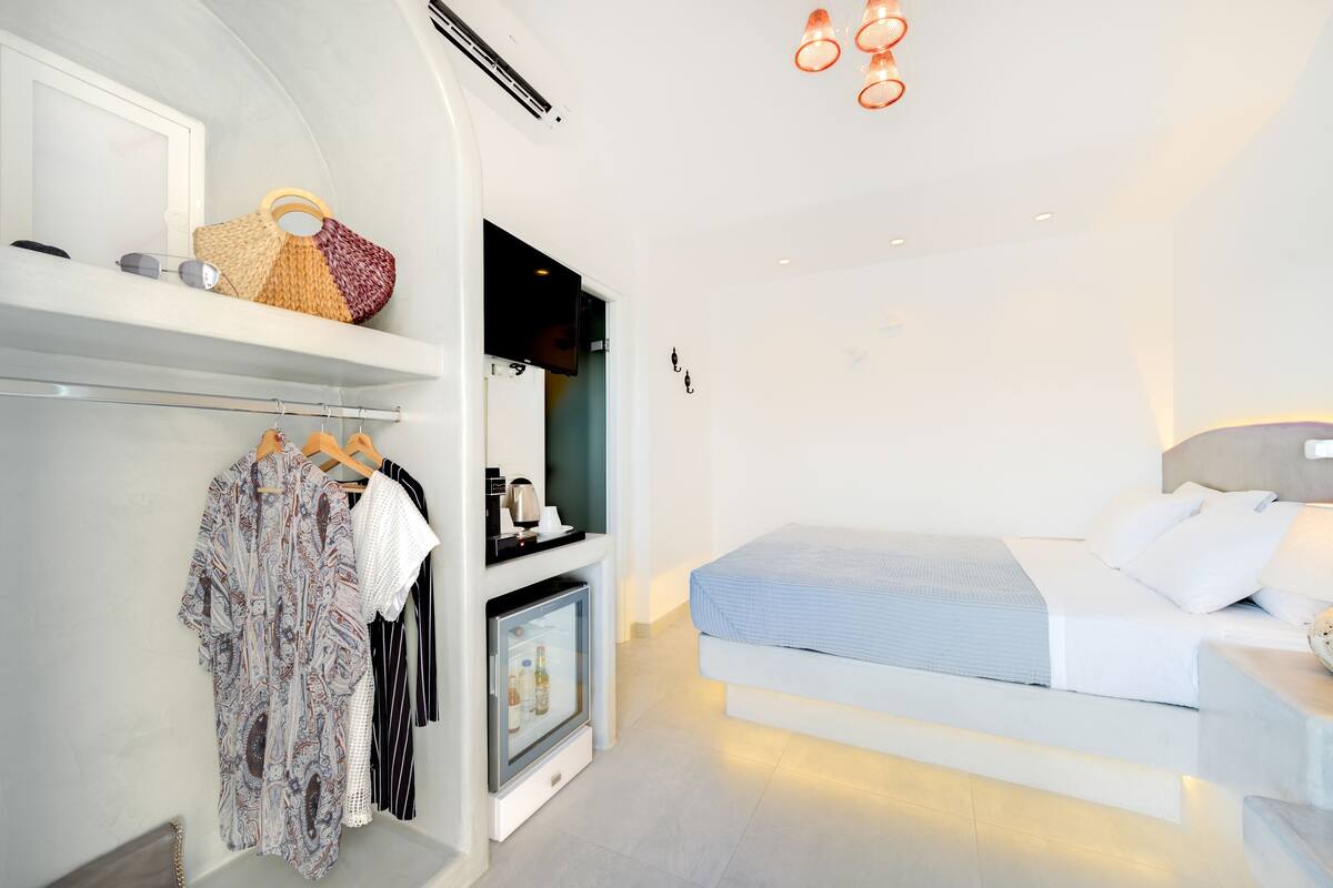 Una habitación de hotel moderna con cama, armario y minibar.