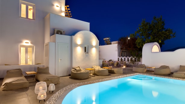 Un área de piscina moderna al aire libre con mobiliario de relax y un ambiente cálido.