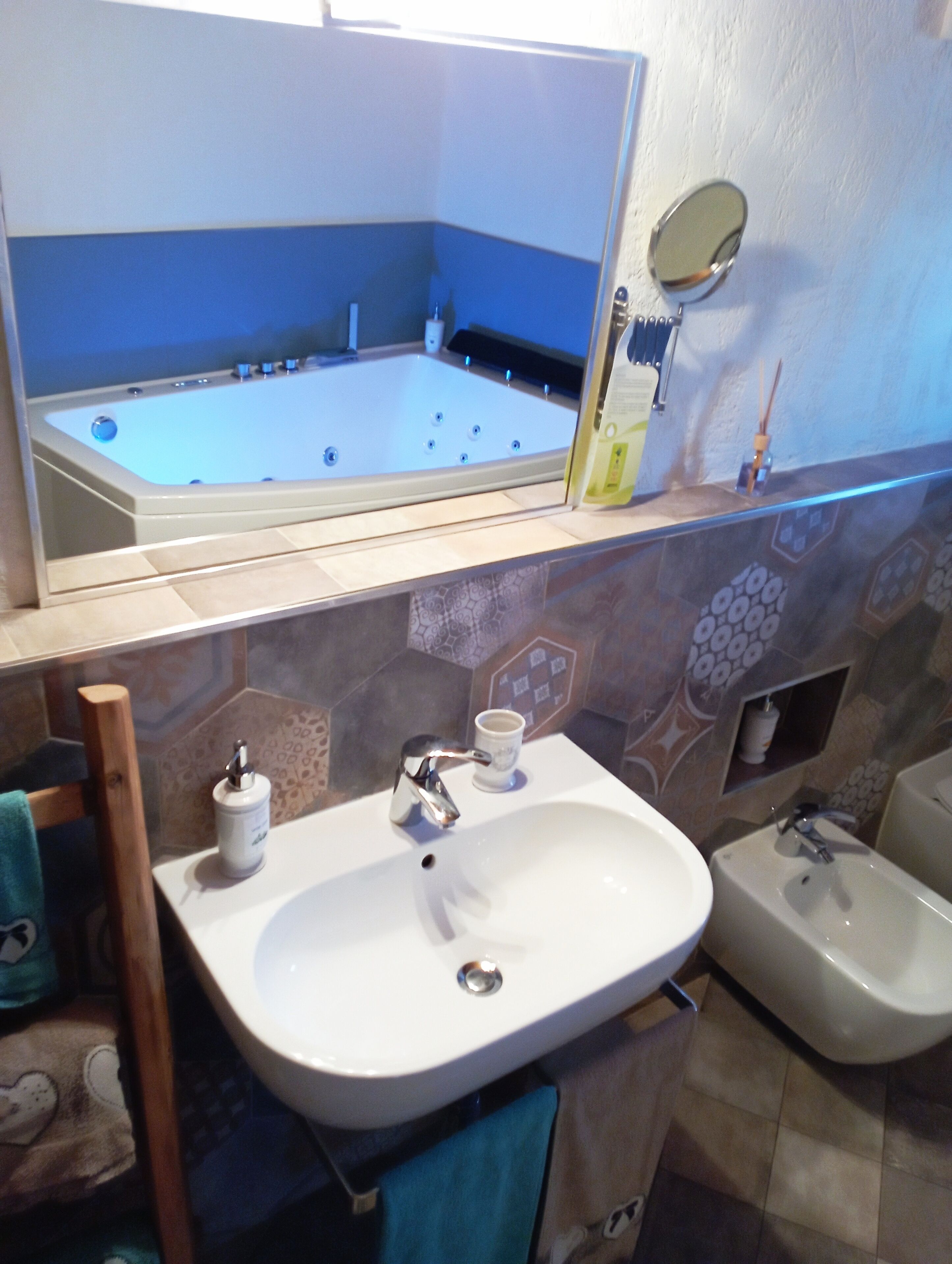 A bathroom with a bathtub, a sink, a mirror, and a bidet.