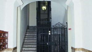Ein Eingangsbereich mit Marmorboden, einem schwarzen Tor und einer Laterne darüber.