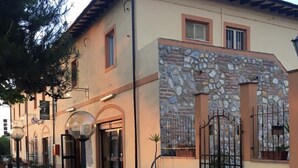 A building with a stone facade, a gated entrance, and potted plants. - Hotel il Malandrone (Castellina Marittima)