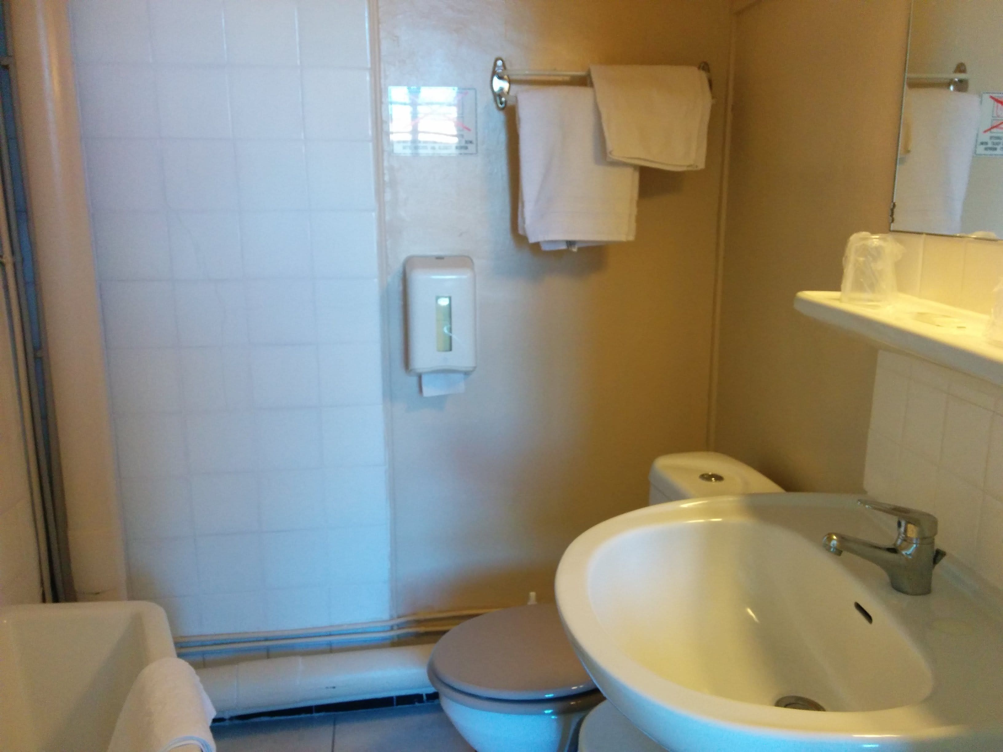 A bathroom with a toilet, sink, and shower.