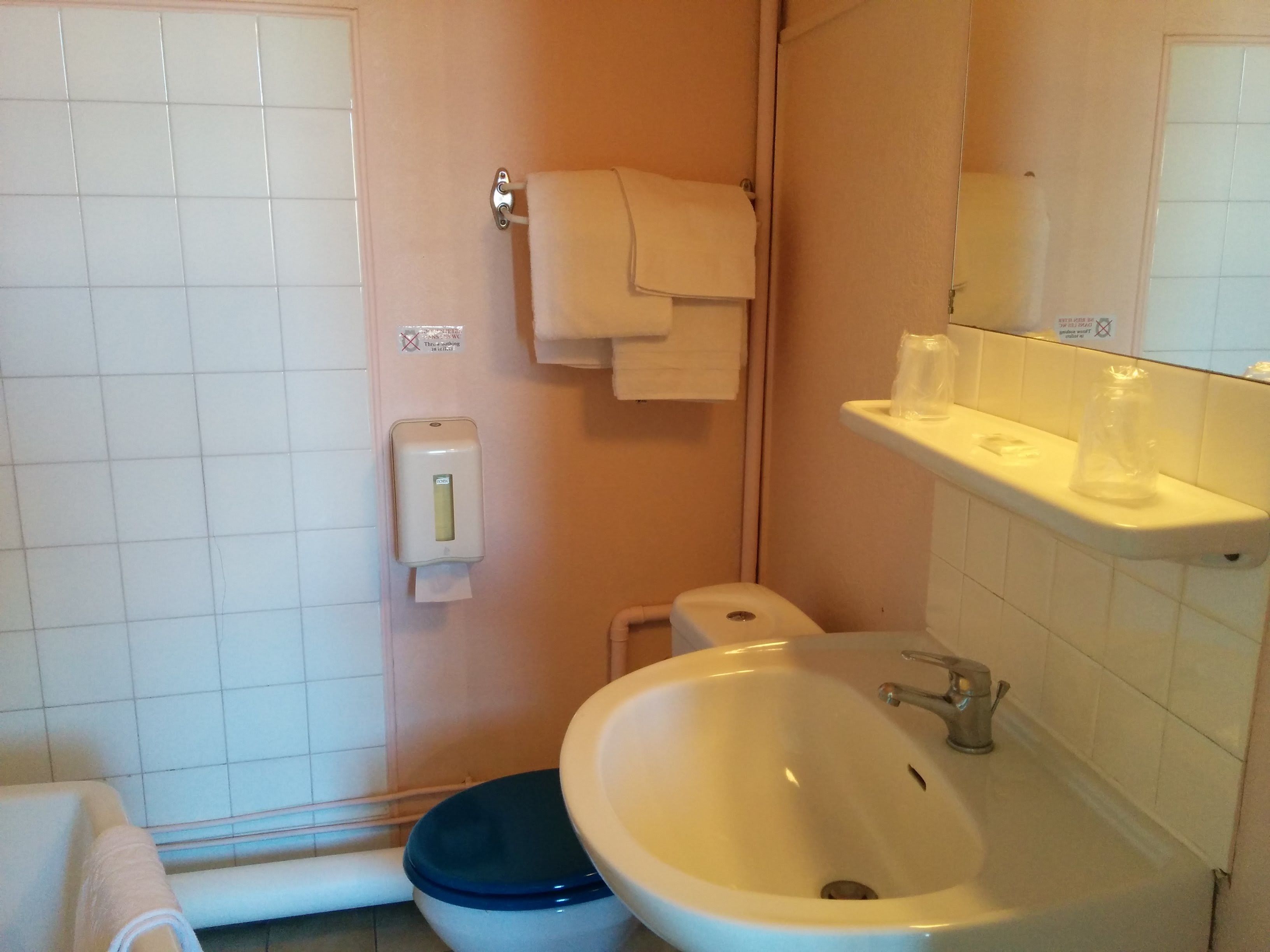 Ein Badezimmer mit Toilette, Bidet, Waschbecken und Handtuchhalter.