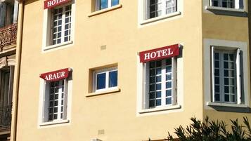 Un bâtiment doté de nombreuses fenêtres, chacune portant l’inscription « ARAUR HOTEL ».