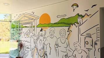 Un mural con un atardecer, una persona parapenteando y un ave.