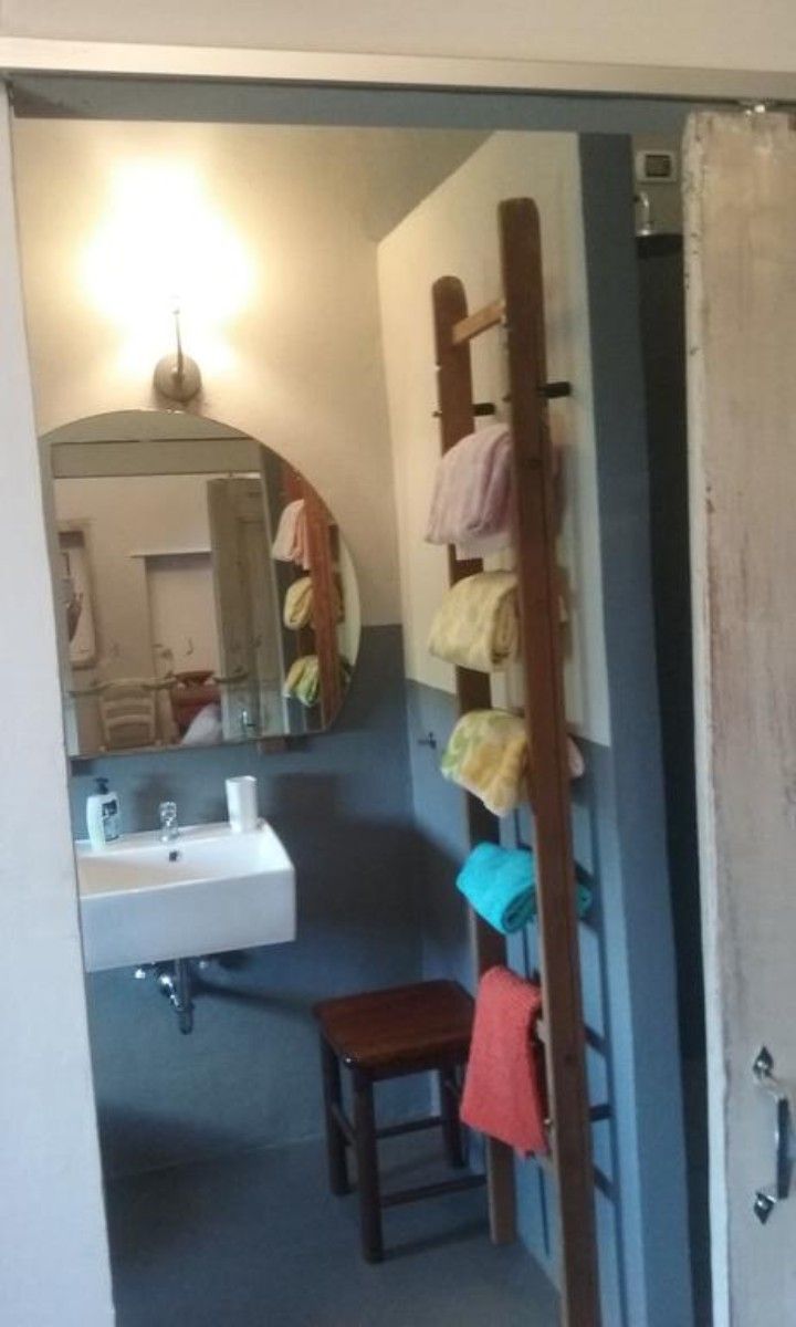 A bathroom with a sink, mirror, and towel rack.