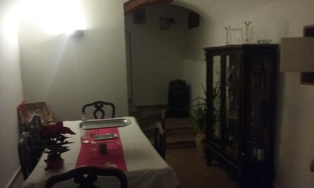 Un coin repas avec une table dressée pour deux personnes, un buffet et un escalier menant à l’étage supérieur.