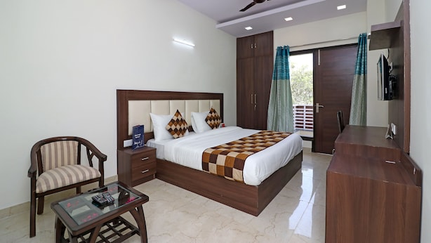 Une chambre à coucher comprenant un lit, une chaise, un bureau, un ventilateur de plafond et une armoire.