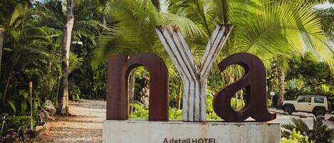 A sign for A detail HOTEL in Montezuma, Costa Rica, with a tropical backdrop.