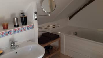 Un baño con lavabo, espejo y bañera.