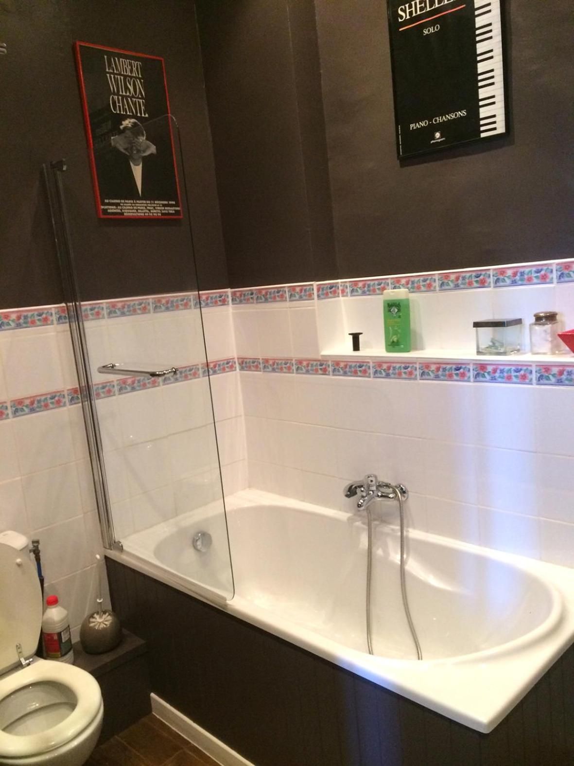 Un baño con bañera, inodoro y ducha. Hay carteles en la pared.