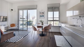 A modern kitchen with a dining area, large windows, and a city view. - Bauhaus Boutique by TLV2rent (Tel Aviv)