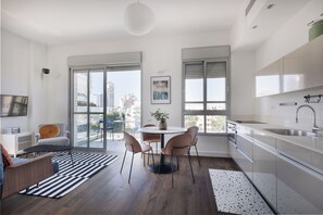 Departamento exclusivo, varias camas | Área de sala de estar | Televisión de pantalla plana de 39 pulgadas con canales digitales 