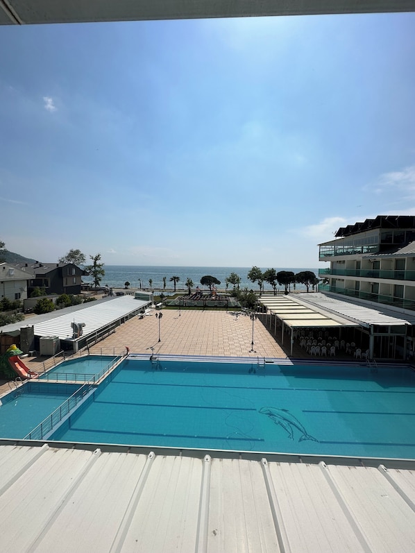 A pool area with a view of the sea, a covered seating area, and a playground. - Cetin Prestige Resort (Erdek)