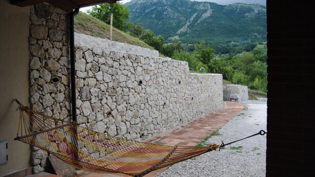 A hammock tied to a stone wall with a view of mountains. - B&B Pascale (Cusano Mutri)