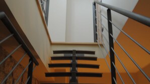 A staircase with a metal railing, a stone wall on one side, and a white wall on the other. - B&B Pascale (Cusano Mutri)