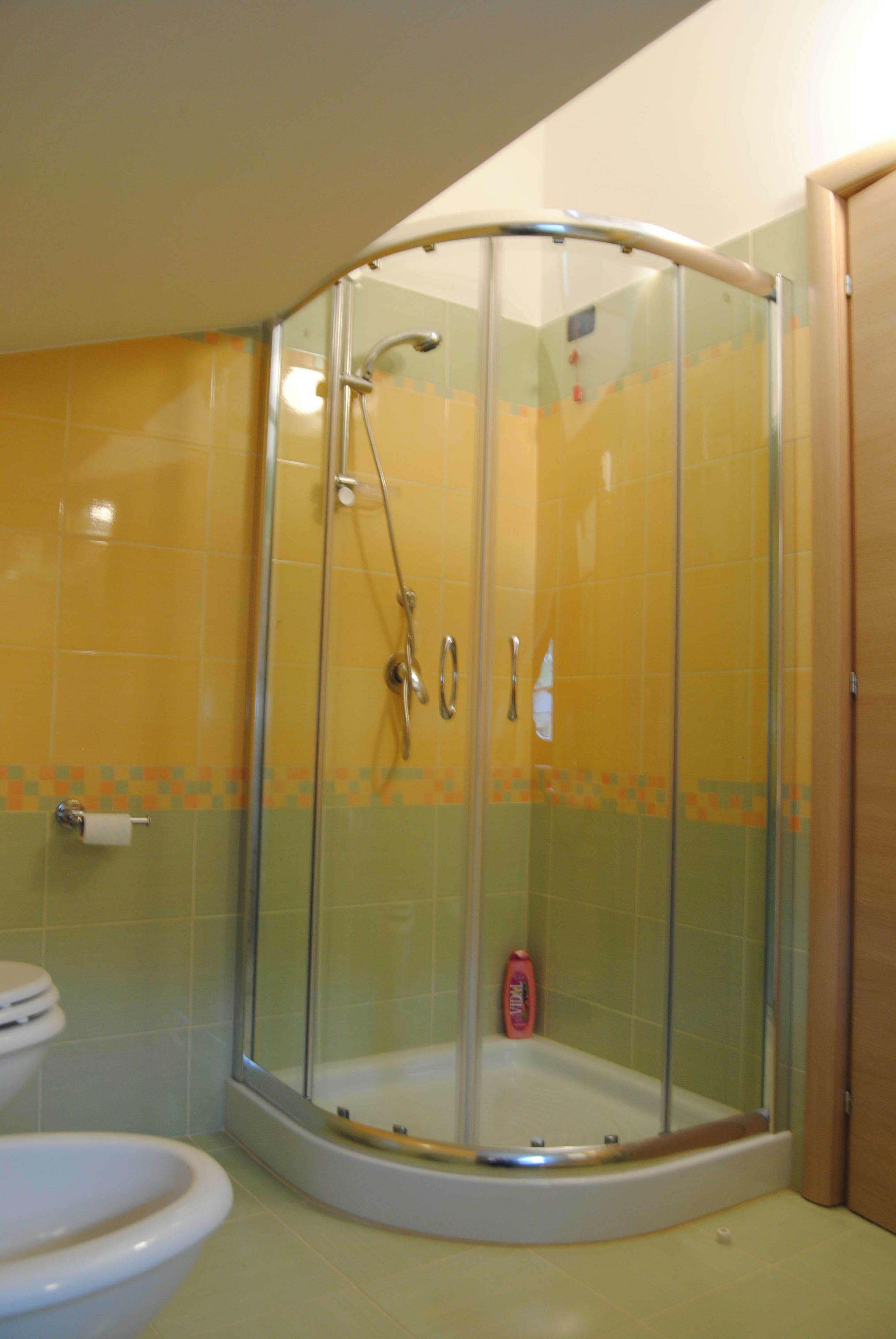 A bathroom with a glass-enclosed shower, a toilet, and a bathtub.