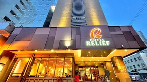 A modern hotel with a prominent 'Hotel Relief' sign, large windows, and a staircase leading to the entrance. - Hotel Relief Sapporo Susukino (Sapporo)