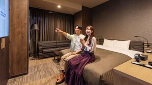 A hotel room with a bed, a desk, a lamp, and a TV screen. - Hotel Relief Sapporo Susukino (Sapporo)